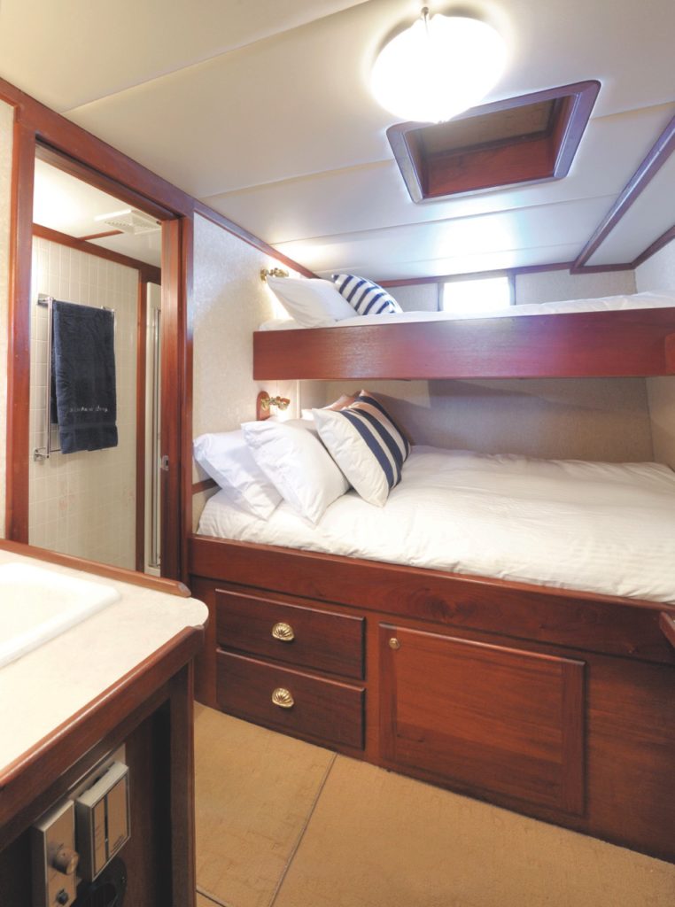 Guest cabin with lower double bed and upper single berth.