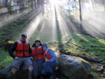 An early morning hike along the trail at Cascade creek trail creates a scenic moment with the sun rising through the forest and rays illuminating the mist from the beautiful nearby cascades.